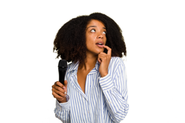 Young African American singer woman holding a microphone isolated relaxed thinking about something looking at a copy space.