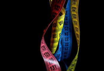colorful measuring tapes on a black background