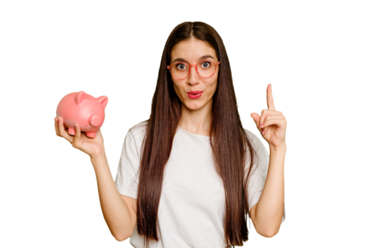 Young caucasian woman holding a piggy bank isolated having an idea, inspiration concept.