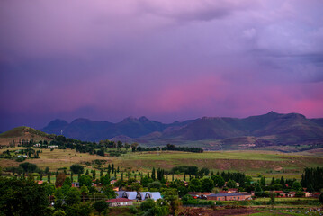 A view of the mountains under a stormy purple sky at sunset in Clarens, South Africa. The popular...