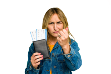 Young caucasian woman holding a passport isolated on green chroma background showing fist to camera, aggressive facial expression.