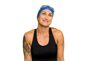 Young caucasian swimmer woman isolated on green chroma background dreaming of achieving goals and purposes