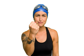 Young caucasian swimmer woman isolated on green chroma background showing fist to camera, aggressive facial expression.