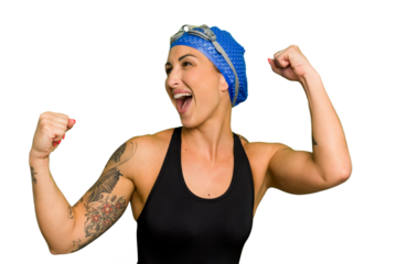 Young caucasian swimmer woman isolated on green chroma background raising fist after a victory, winner concept.