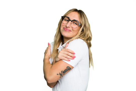 Young caucasian woman isolated on green chroma background hugs, smiling carefree and happy.