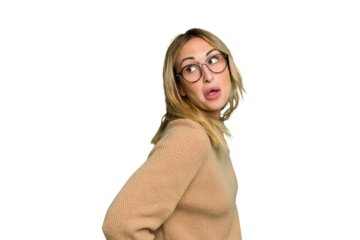 Young caucasian woman isolated on green chroma background looks aside smiling, cheerful and pleasant.