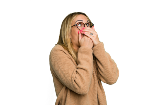 Young caucasian woman isolated on green chroma background thoughtful looking to a copy space covering mouth with hand.