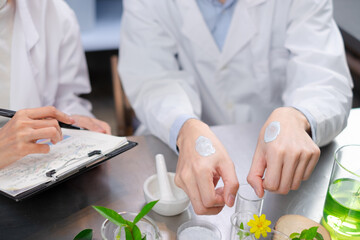 Close up hand's of Scientist is comparing the result of lotion in beauty laboratory. Concept of...