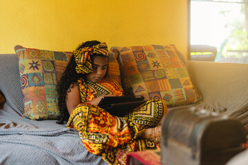 Imagen horizontal de una pequeña niña sentada en un sofá  sola en el interior de su casa...