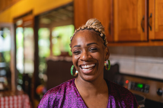 Retrato horizontal de una hermosa mujer afrocaribe&ntilde;a en el interior de su hogar muy sonriente mirando a c&aacute;mara. 