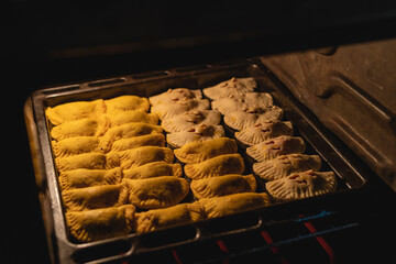 Imagen horizontal de unas deliciosas empanadas al estilo caribeño en el interior de un horno.