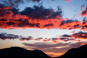 Sunset colouring the clouds read over mountains