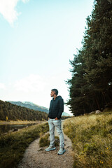Portrait of a boy posing in a lake next to a forest