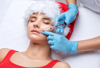 The cosmetologist makes anti-aging anti-wrinkle injections on the face of a beautiful woman in a...