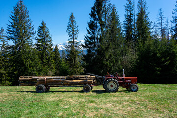 Stary traktor i bale drewna
