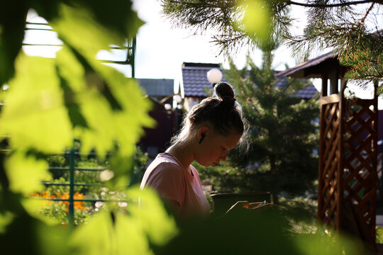 A teenage girl listens to music in the country