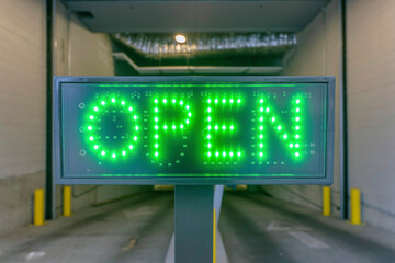 Close up of Open sign at the entrance of an indoor paid parking area