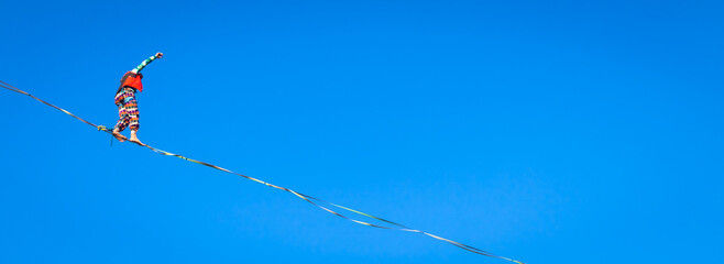 Slackline athlete during his performance. Concentration, balance and adventure in this dynamic sport.