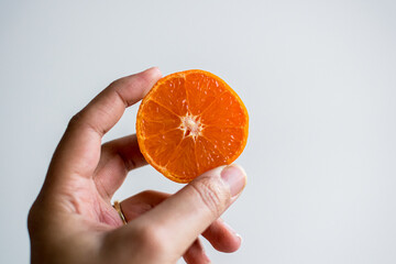 African American woman, Black woman hand holding a half cut cross section satsuma mandarin orange,...