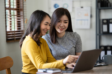 Beautiful smiling young woman working on computer at her workplace in office