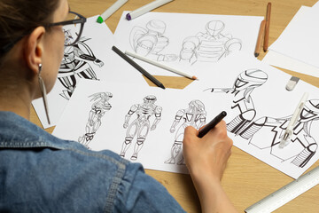 The artist draws sketches of robotic characters for a computer game.