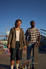 Two young non-binary skateboarders in skatepark
