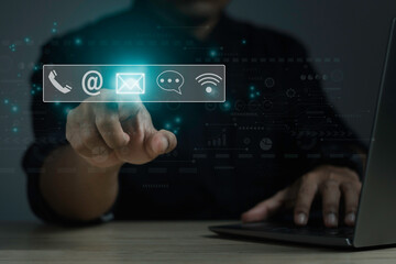 Businessman using a laptop and touching on virtual screen contact icons. Contact us concept.
