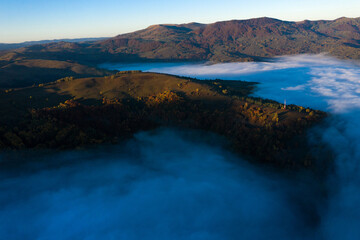 Aerial view of mist and clouds in the valley in sunrise