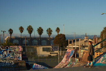 Young non-binary skating on skateboard at skatepark © Sheilby Macena