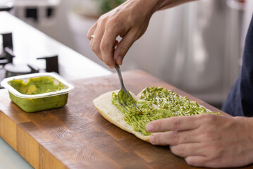 Chef cook hands making fresh diet avocado toast on bread with fork. Vegetarian and vegan cuisine....