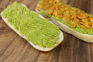 Close up of fresh diet avocado toast with seafood shrimps. Healthy vitamin breakfast.