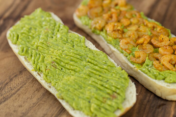Close up of fresh diet avocado toast with seafood shrimps. Healthy vitamin breakfast.