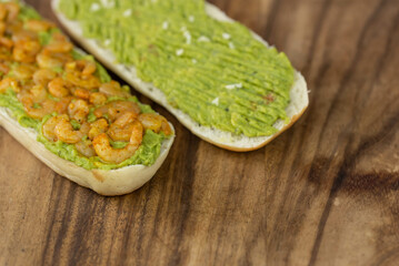Close up of fresh diet avocado toast with seafood shrimps. Healthy vitamin breakfast.