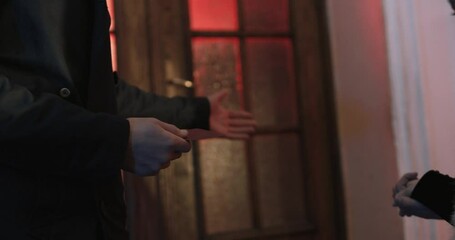 Close up of businessman in black suit giving to concierge pass card for entering luxury casino with vip service. Lifestyles of celebrity people.