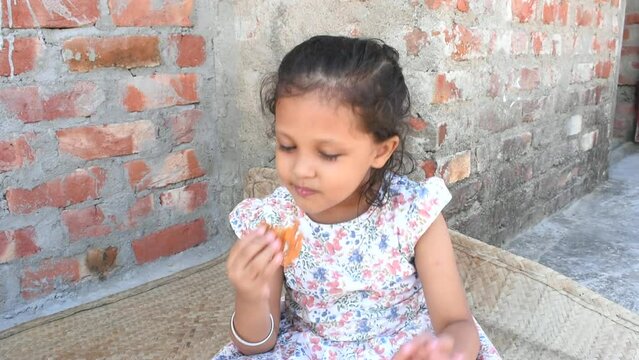 A girl eating yummy homemade jalebi and giving tasty expression.