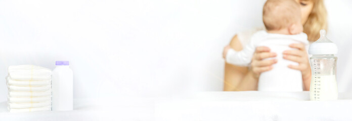 Mother feeds the baby from a bottle. Selective focus.