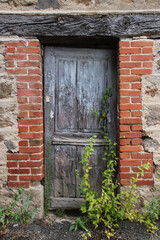 porte ancienne encadrée de briques rouges à l'abandon