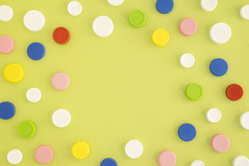 Top view of multicolored plastic bottle caps in a chaotic pattern on a green background