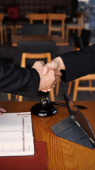 Lawyer and customer are working in lawyer company for discussing about legal with attorney indoor. Justice and judge hammer in on table.