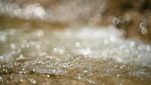 A mountain stream with bubbles and bokeh (slow motion)
