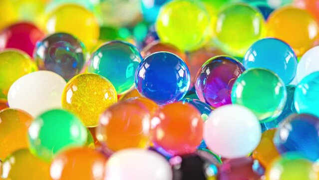 4K Time Lapse of Water beads growing in water close-up, abstract background. Texture of Hydrogel jelly balls - many colorful orbeez.