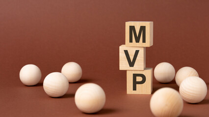 wooden blocks with text MVP on yellow paper, business concept. mvp - short for minimum viable product