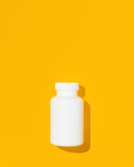 Blank white bottle plastic tube on yellow background, flat lay. Space for text. Mockup.