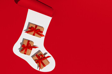Christmas sock with gifts on white and red background. Space for text. Mockup.