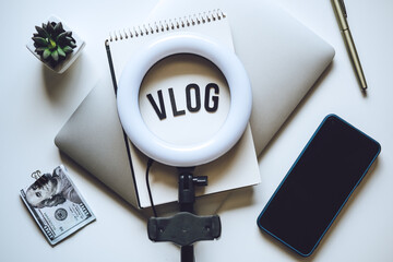 How To Do Vlog. Word Vlog and Laptop, Mobile Phone, notebook and glasses on the table