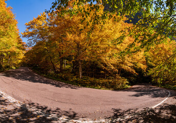 Narrow hairpin bend in the road through Smugglers Notch in the fall - obrazy, fototapety, plakaty