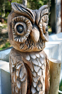 A picture of a wooden sculpture of an owl totem