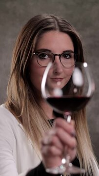 Young woman with a glass of red wine - studio photography - Vertical video