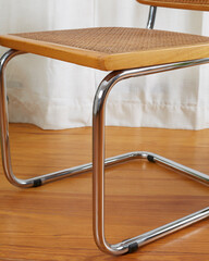 Vintage mid-century modern wooden chrome and cane Cantilever chair, seat and legs detail.