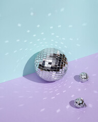 Creative minimal still life with mirrored disco balls on pastel background. Party concept. visual trend. Retro aesthetic